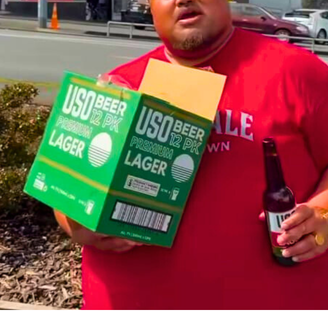 Customer holding a box of USO Premium Lager